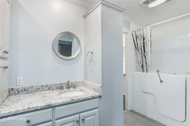 a bathroom with a granite countertop sink and a mirror