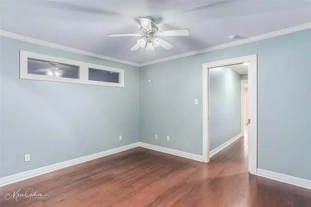 a view of an empty room with wooden floor