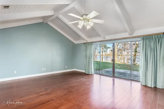 a view of a backyard with plants and large trees