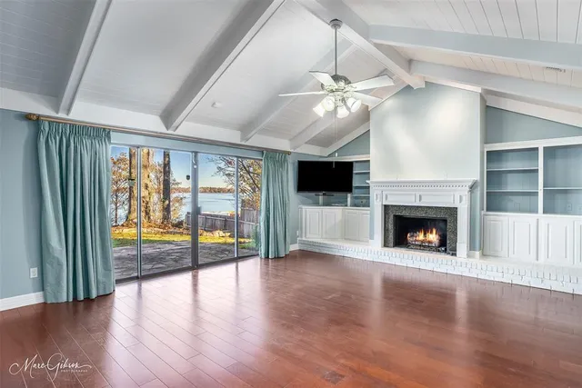 an empty room with fireplace fan and windows