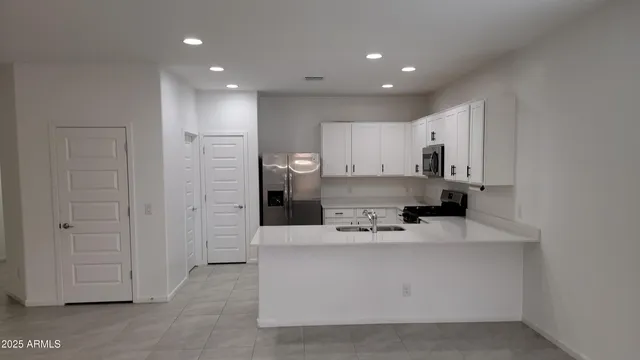 a large white kitchen with kitchen island a sink a stove and refrigerator