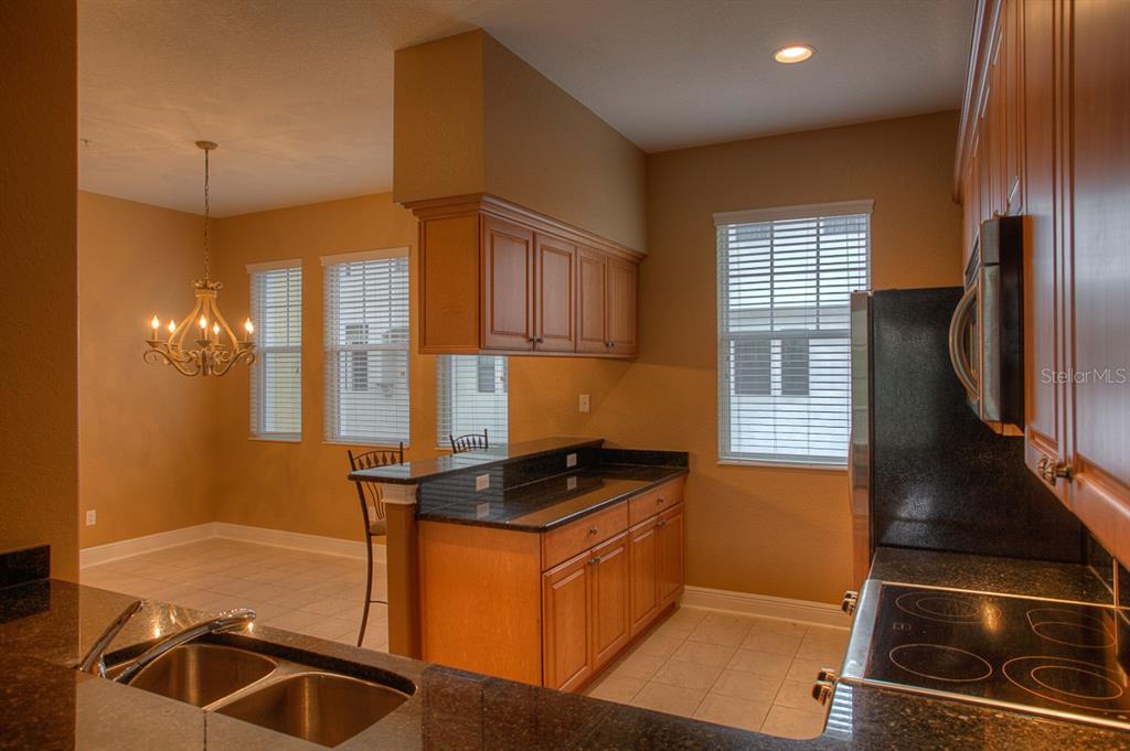 6021 Printery Street, Unit 106 Tampa, FL 33616 - Photo 5 of 23 a kitchen with granite countertop a sink stainless steel appliances and cabinets