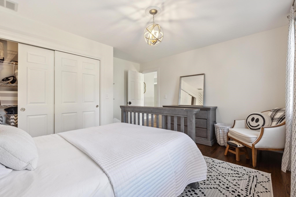 8 MacIntyre Drive North Reading, MA 01864 - Photo 33 of 42 a bedroom with a bed a chandelier and a dresser