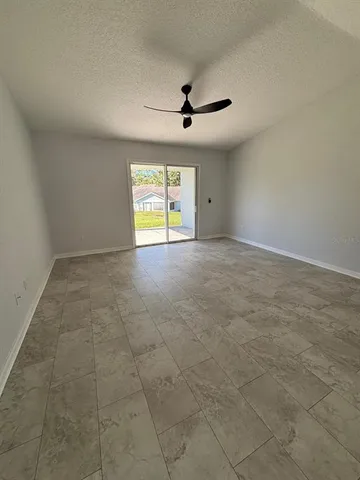 an empty room with windows and ceiling fan