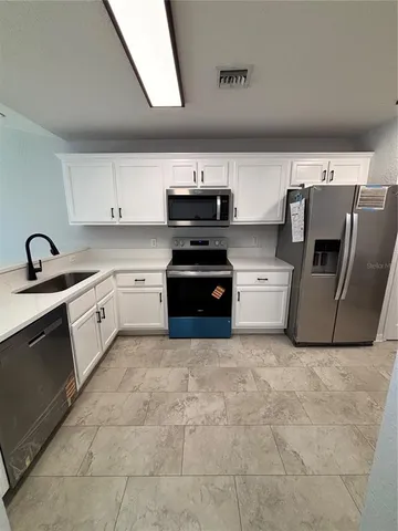 a kitchen with cabinets and white stainless steel appliances