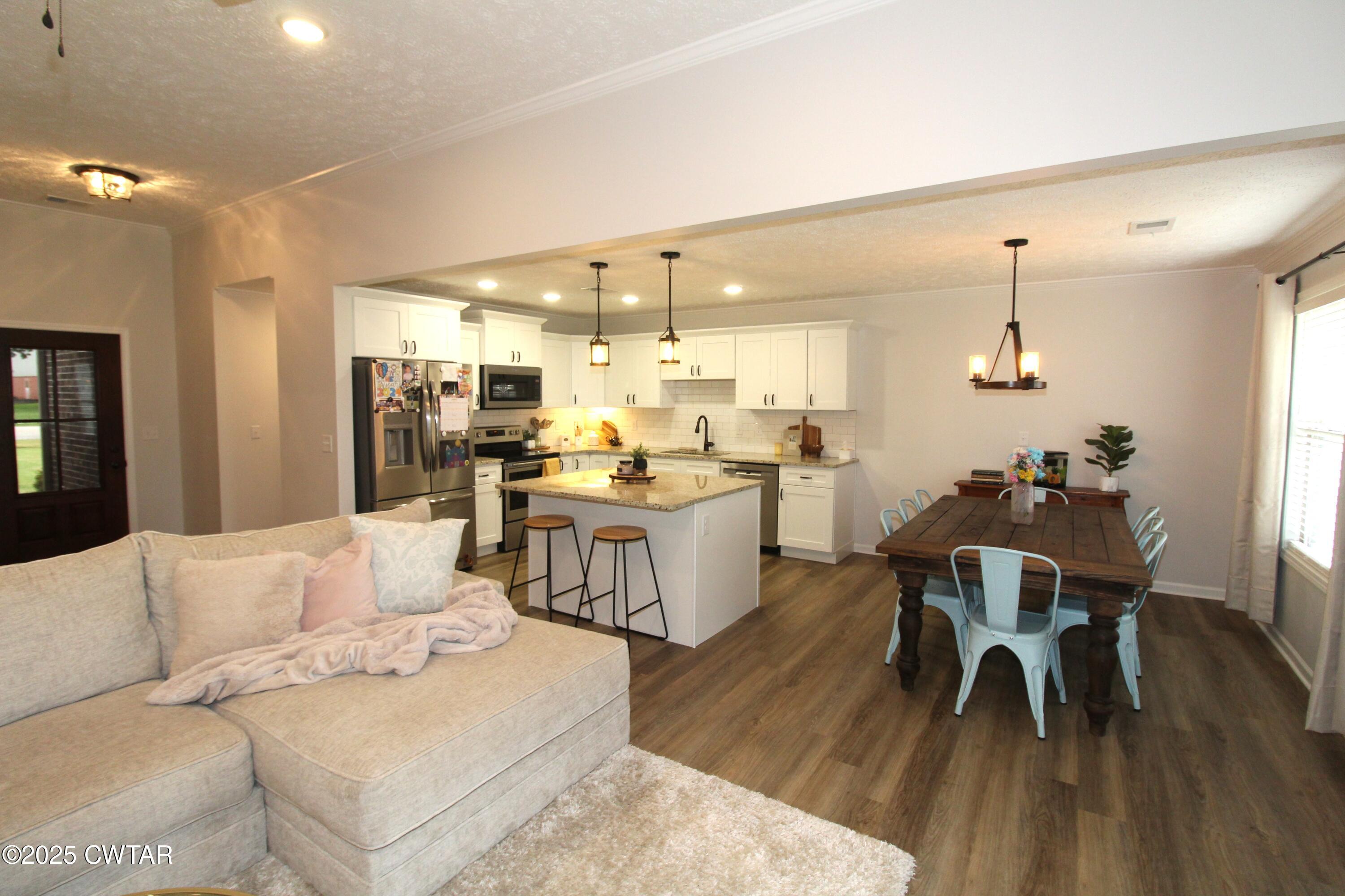 6151 Windsor Drive Milan, TN 38358 - Photo 7 of 25 a living room with furniture and a dining table with wooden floor