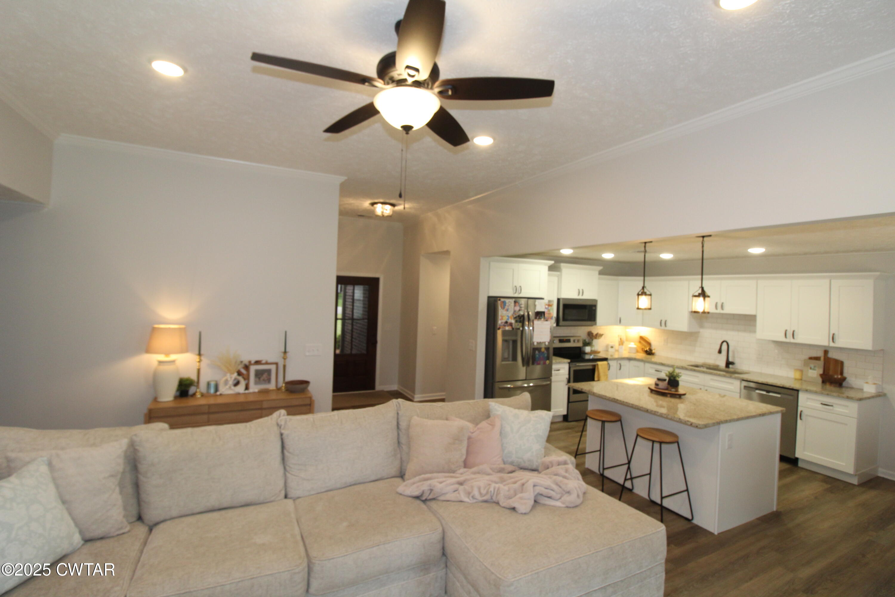 6151 Windsor Drive Milan, TN 38358 - Photo 8 of 25 a living room with couches kitchen view and a chandelier
