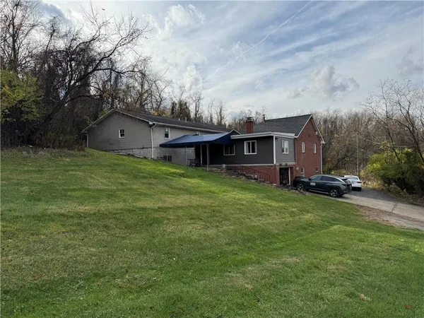 an aerial view of house with yard and trees in the background