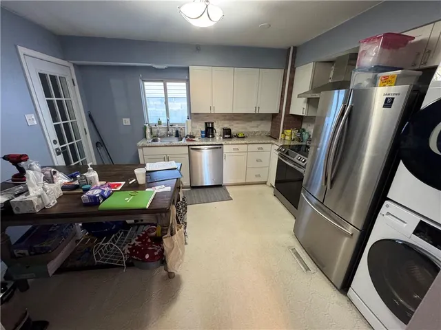 a kitchen with stainless steel appliances a stove a sink and a refrigerator