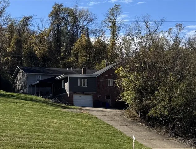a front view of a house with a yard and mountain view