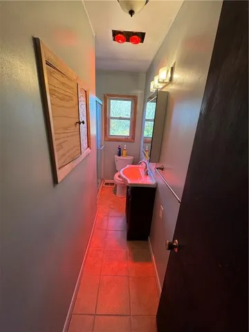 a hallway with sitting area and bathroom view