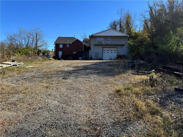 a front view of a house with a yard and trees