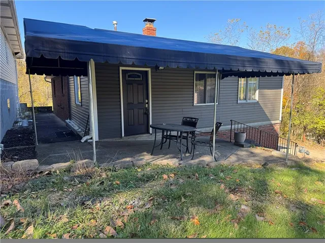 a view of backyard with seating space and wooden fence