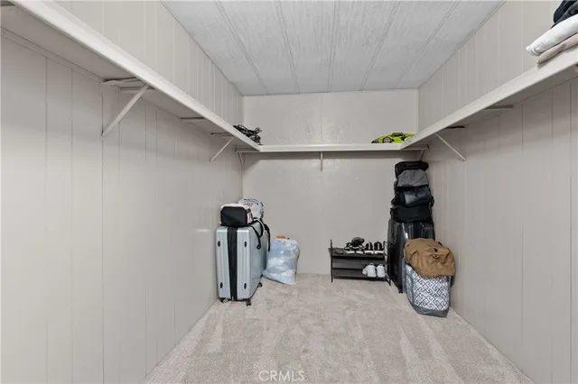 a walk in closet with wooden floor