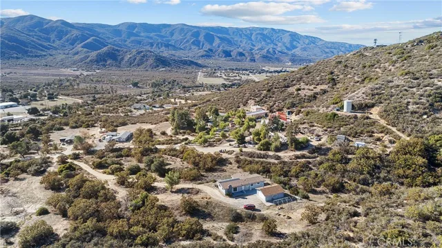 a view of a dry yard with mountains in the background
