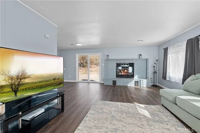 a living room with furniture flat screen tv and wooden floor