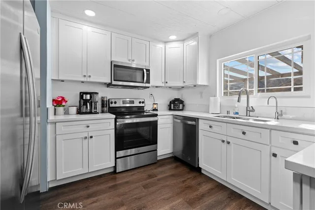 a kitchen with white cabinets and white appliances
