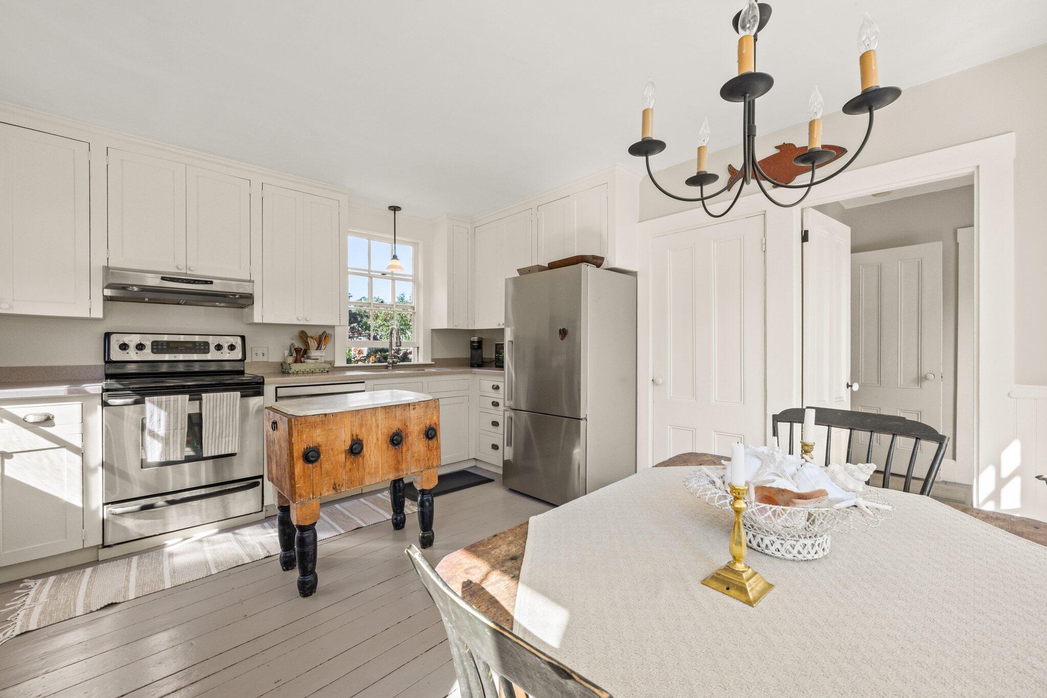 1955 Bridge Road Eastham, MA 02642 - Photo 20 of 77 a kitchen with stainless steel appliances a dining table chairs and stove
