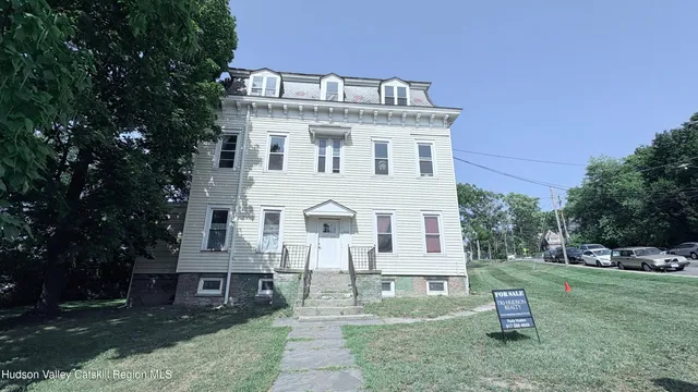 a view of a white house with a yard