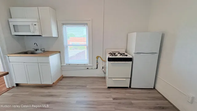 a kitchen with a refrigerator stove and white cabinets