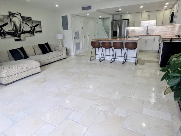 a living room with furniture and kitchen view