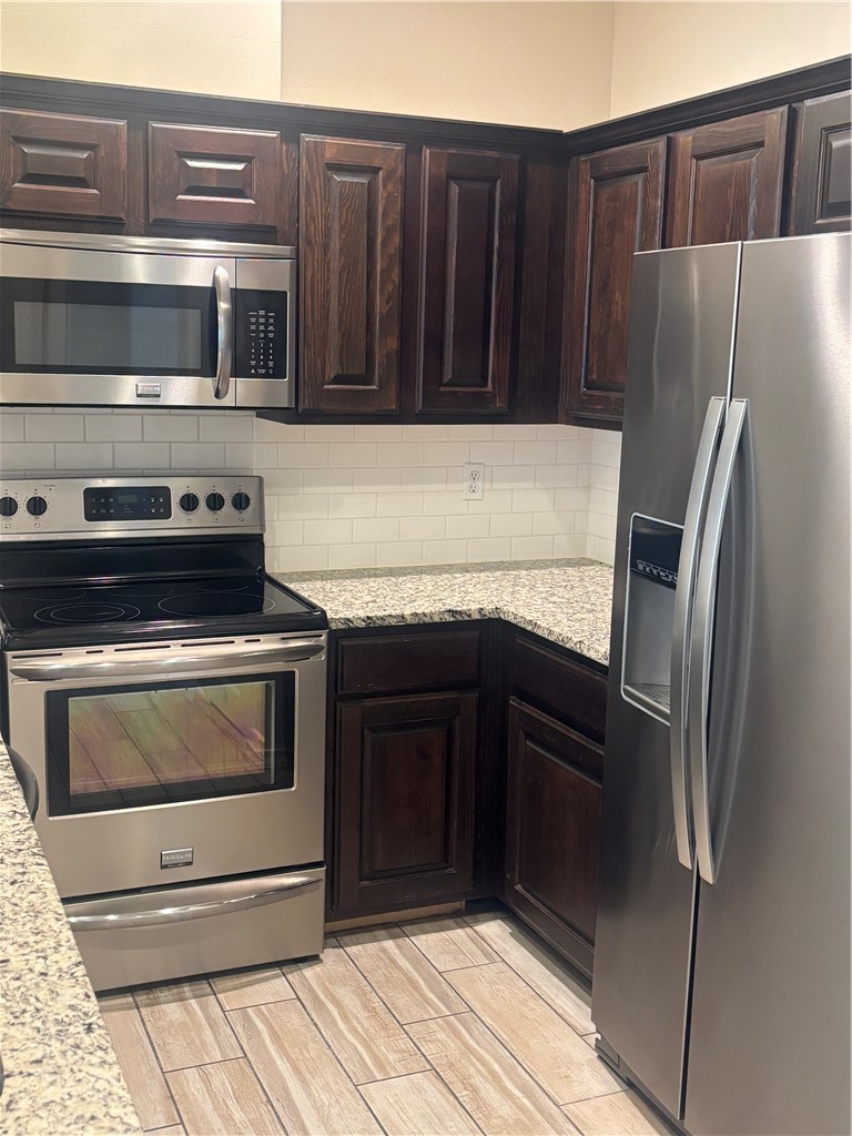 921 Moore Avenue Portland, TX 78374 - Photo 5 of 18 a kitchen with granite countertop a refrigerator stove and cabinets