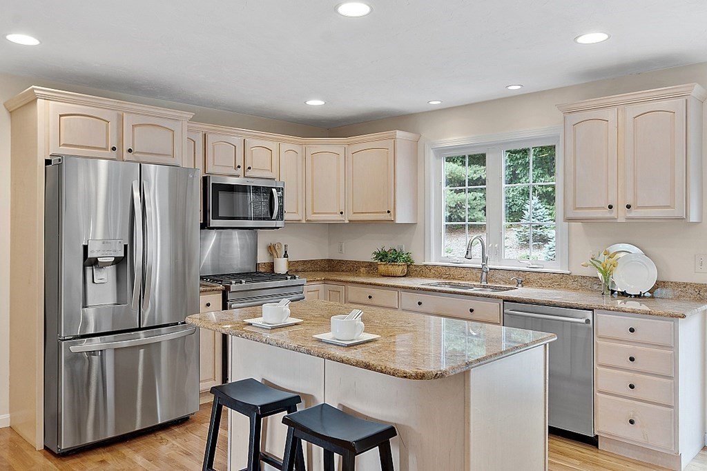 12 Whitetail Way Littleton, MA 01460 - Photo 10 of 39 a kitchen with granite countertop a refrigerator stove a sink and dishwasher with wooden floor