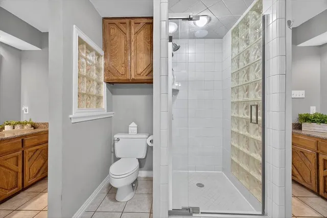 a bathroom with a granite countertop bathtub shower and toilet