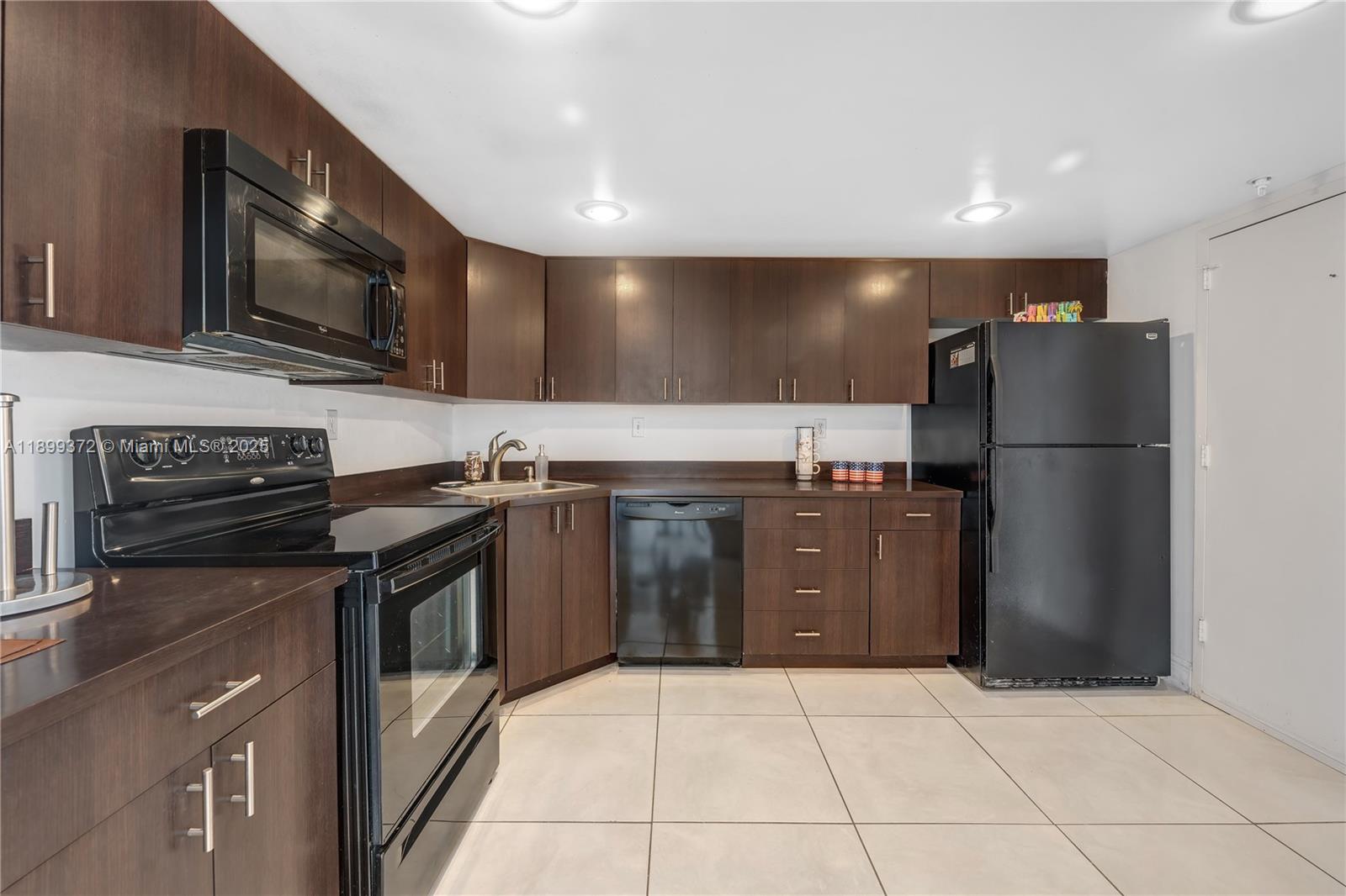 2750 Northeast 183rd Street, Unit 804 Aventura, FL 33160 - Photo 8 of 15 a kitchen with stainless steel appliances granite countertop a stove a refrigerator and a microwave