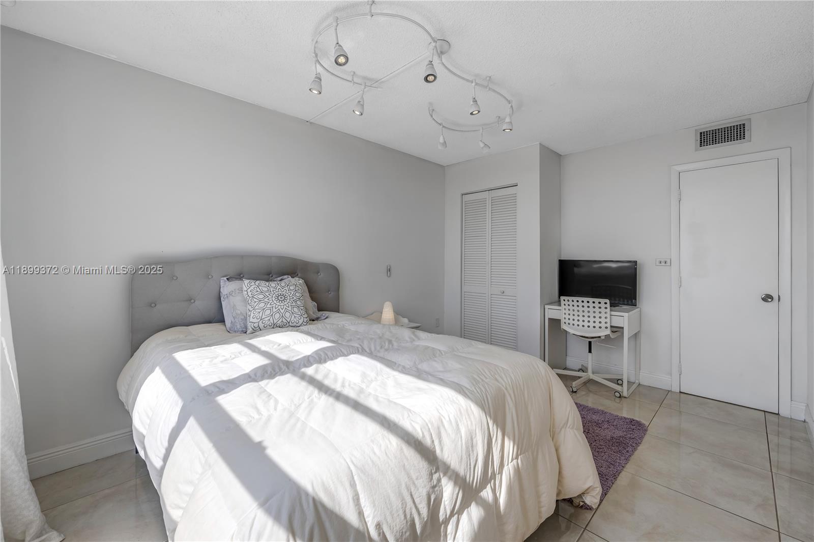 2750 Northeast 183rd Street, Unit 804 Aventura, FL 33160 - Photo 10 of 15 a bedroom with a bed and a flat screen tv