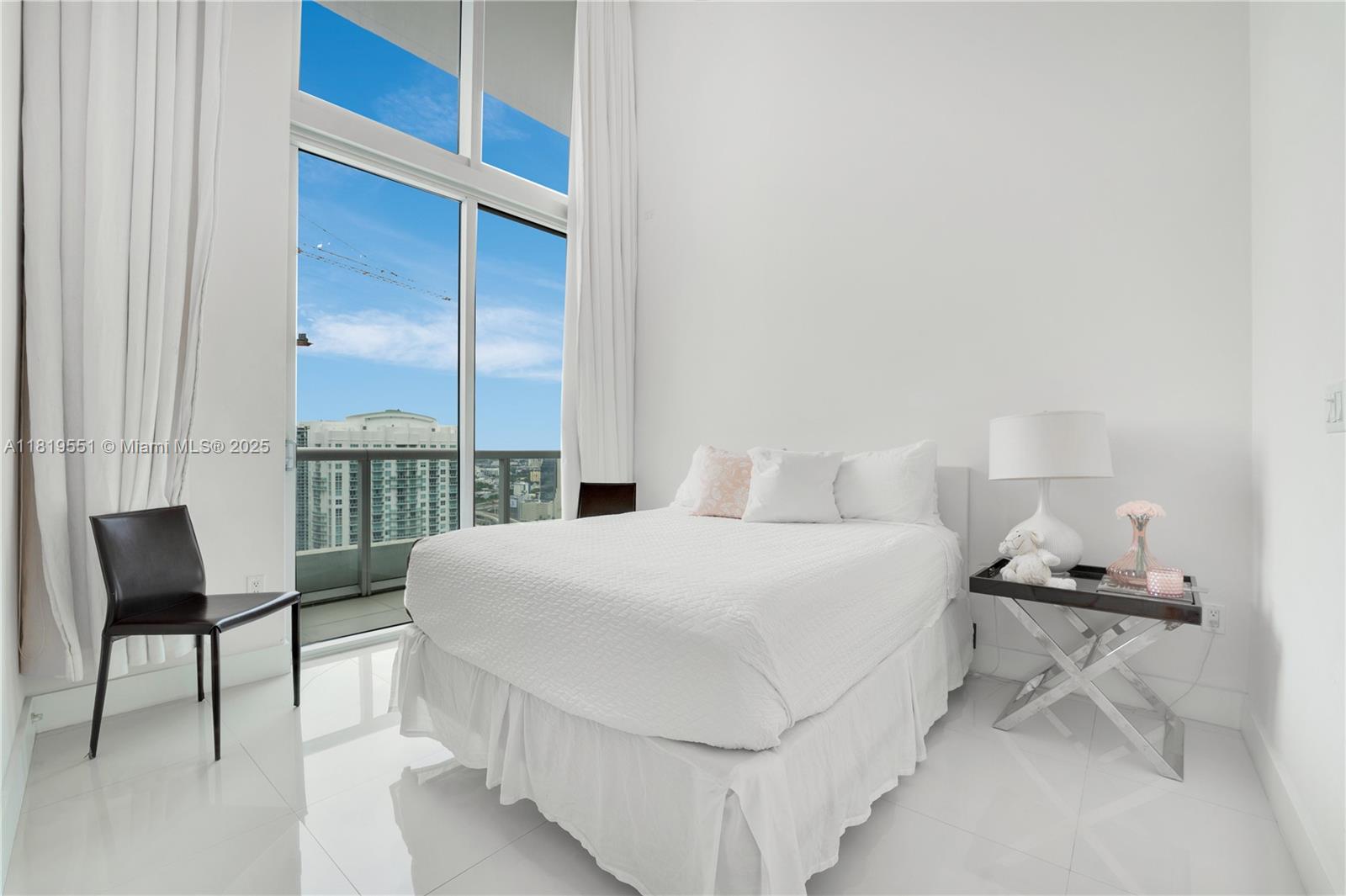 485 Brickell Avenue, Unit 4004 Miami, FL 33131 - Photo 20 of 22 a bedroom with a bed a chair and a large window