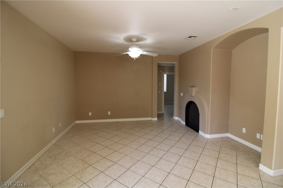 754 Rise Canyon Drive Henderson, NV 89052 - Photo 9 of 34 A gracefully arched fireplace anchors this spacious room with practical tile flooring.