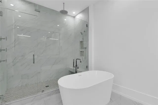 a white bath tub sitting in a bathroom and shower