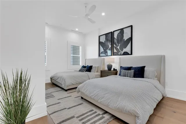 a bedroom with two beds and a potted plant