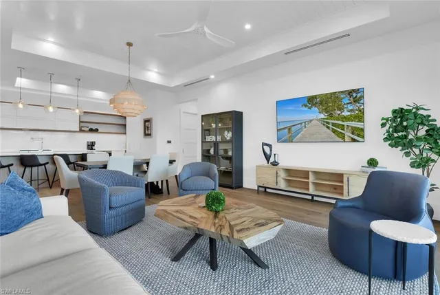 a living room with furniture kitchen view and a large window