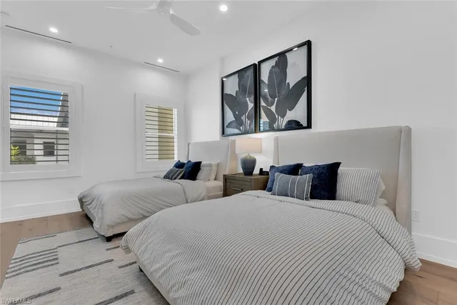 a bedroom with two beds and a large window