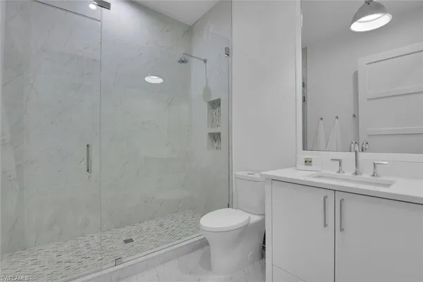 a bathroom with a granite countertop sink a toilet and shower