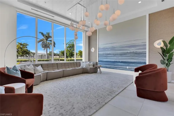a living room with furniture flowerpot and a chandelier