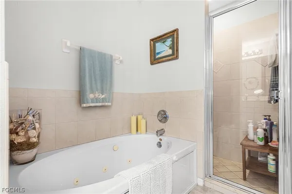 a bathroom with a tub a sink and wooden floor