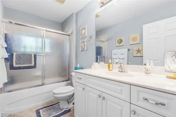 a bathroom with a granite countertop sink toilet a mirror and shower