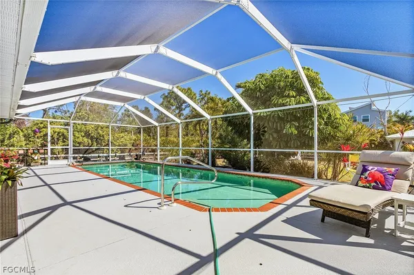 a view of a backyard with table and chairs under an umbrella