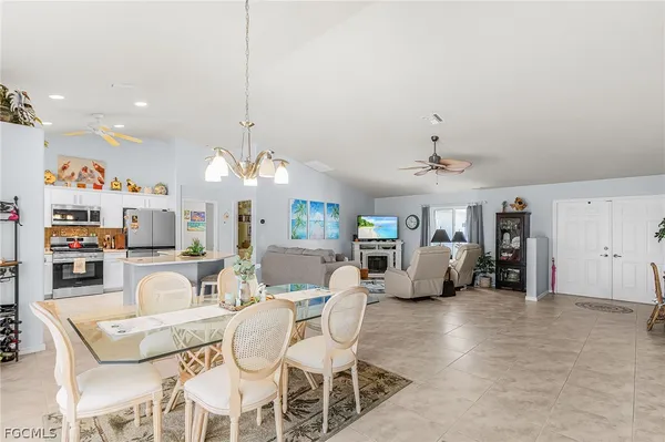 a living room with furniture a chandelier and kitchen view