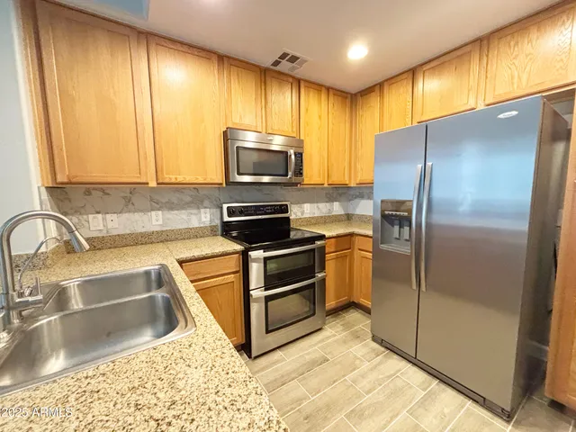a kitchen with a refrigerator sink and cabinets