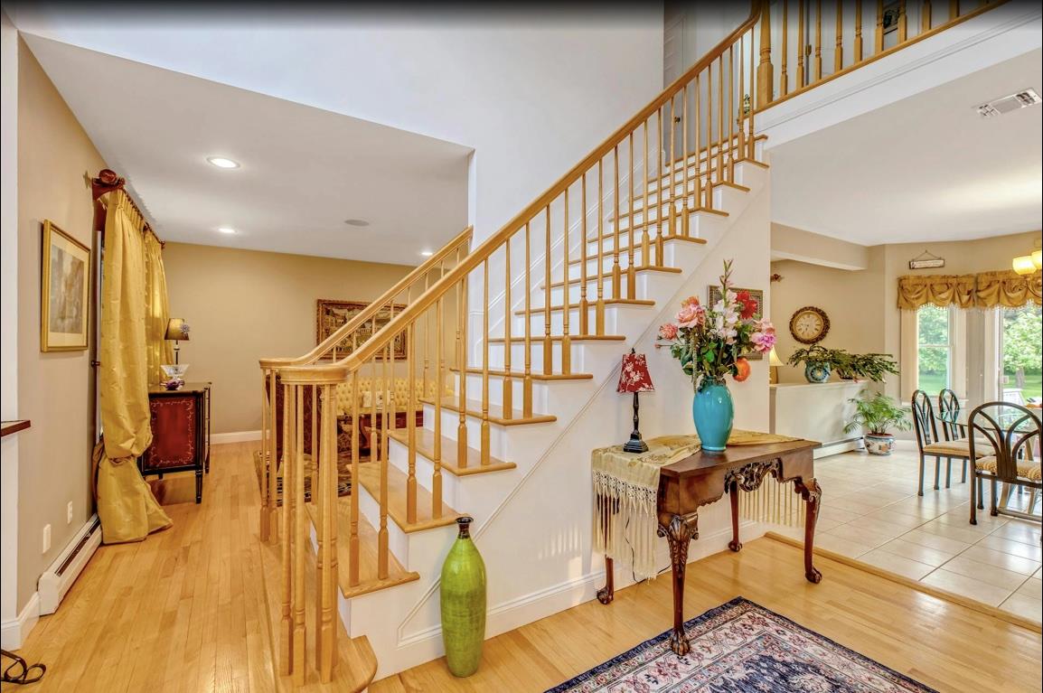2655 Rocky Point Road East Marion, NY 11939 - Photo 4 of 23 Stairs with visible vents, a baseboard radiator, baseboard heating, and wood finished floors