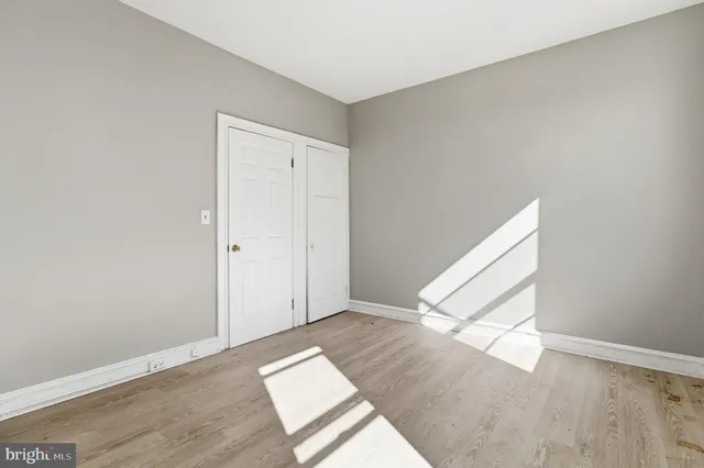 an empty room with wooden floor and entryway