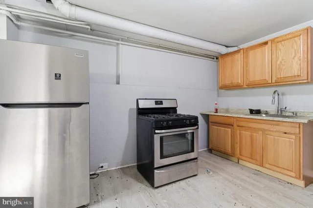 a kitchen with granite countertop a sink stove and refrigerator