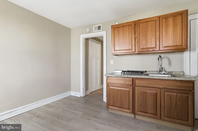 a kitchen with granite countertop wooden cabinets and sink