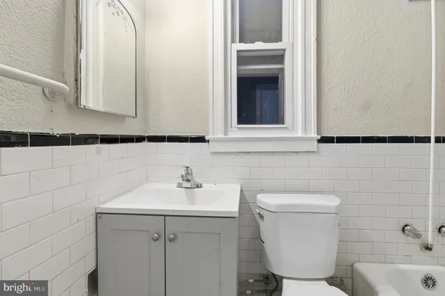 a bathroom with a sink a toilet and mirror