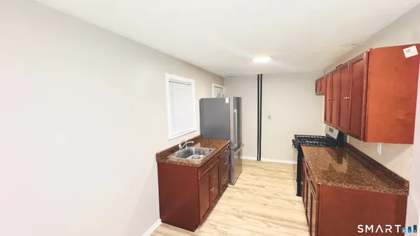 a kitchen with stainless steel appliances granite countertop a refrigerator a stove and a microwave