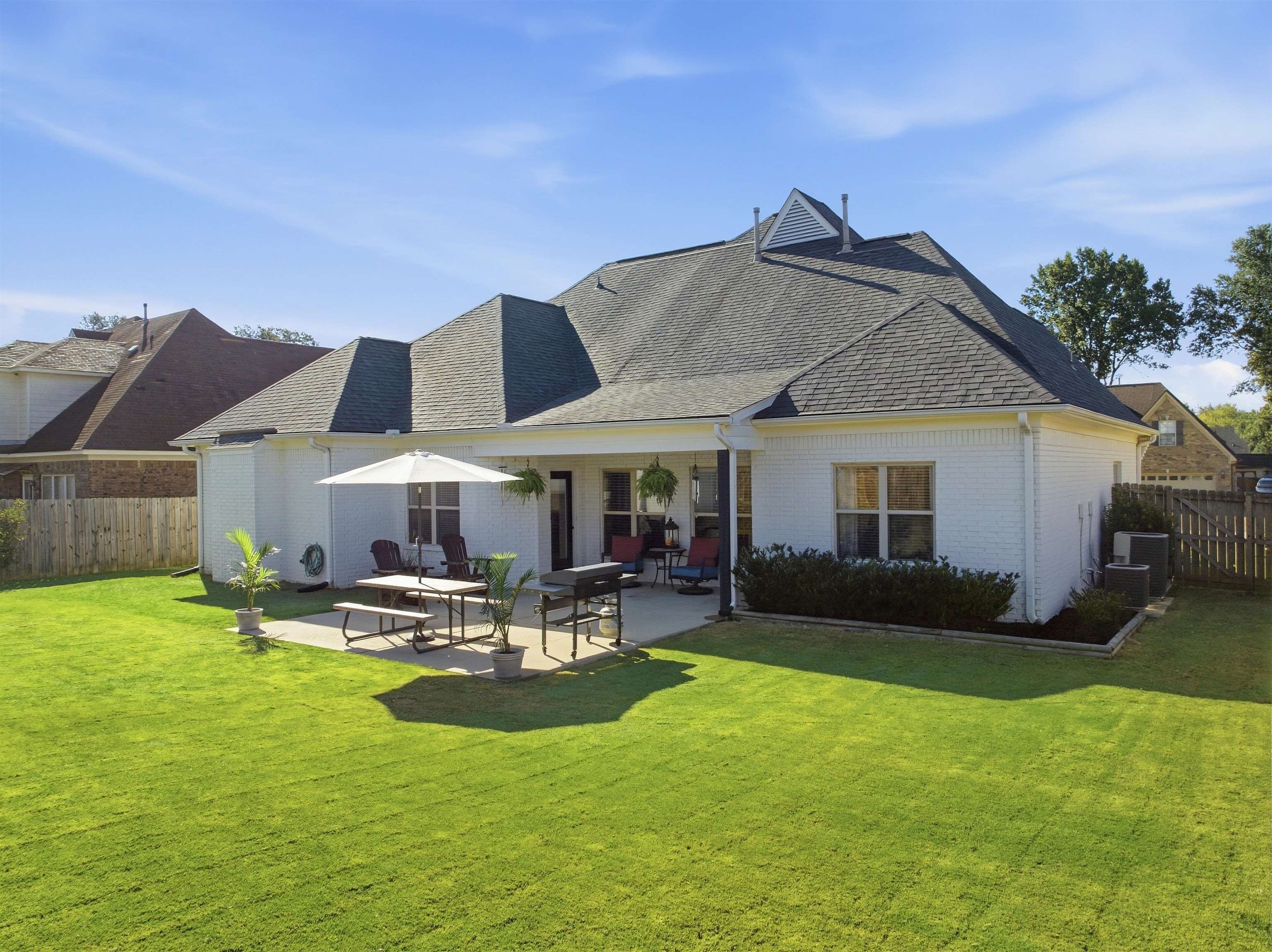 7920 Pips Ridge Lane Bartlett, TN 38133 - Photo 37 of 40 Expansive green lawn, white brick exterior, covered patio, concrete patio, and a gabled roofline